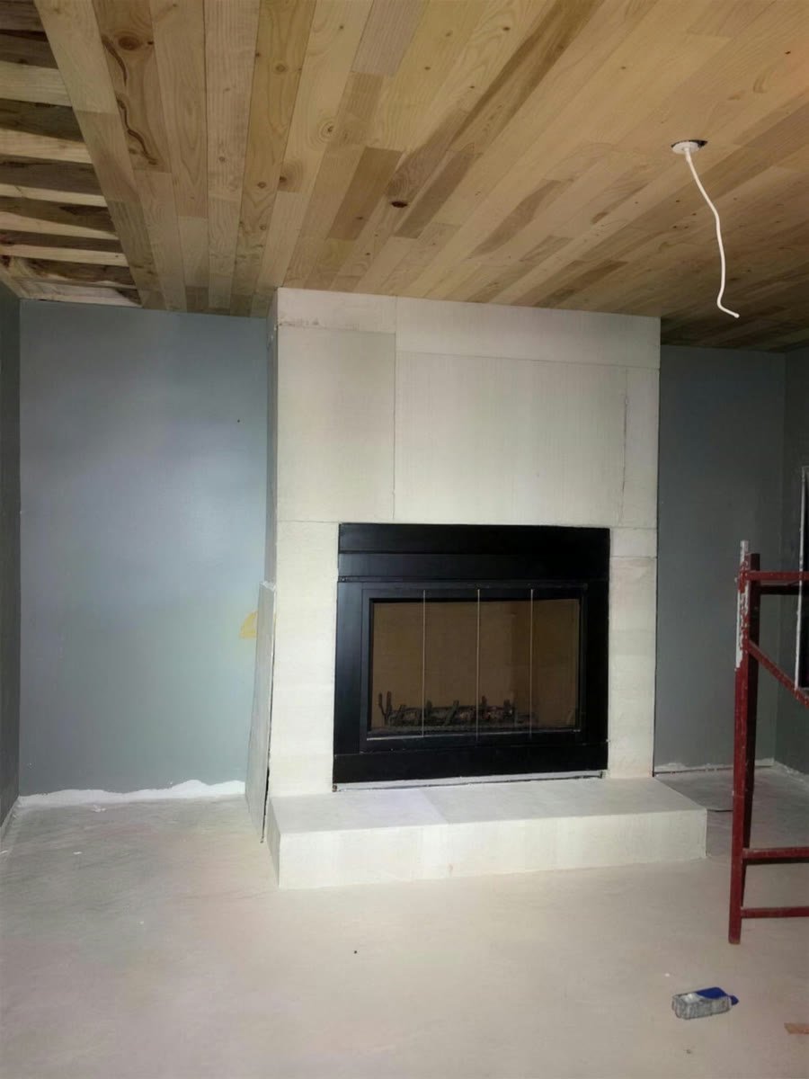 New fireplace with a tile surround in a room under construction